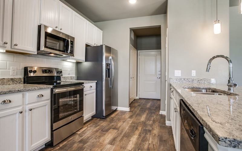 kitchen on wood-style flooring, with modern appliances and easy to access hallway
