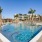 pool with reclining seats and lush landscaping