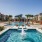 pool with reclining seats and lush landscaping