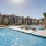pool with reclining seats and lush landscaping