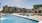 pool with reclining seats and lush landscaping